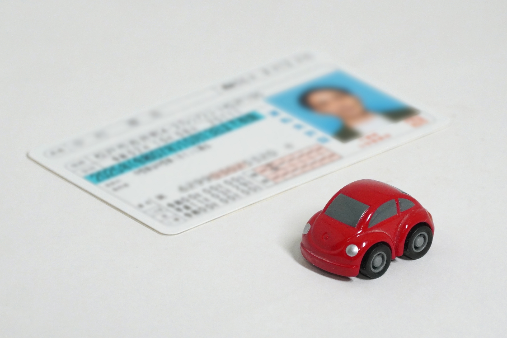 運転免許証と赤い車の模型