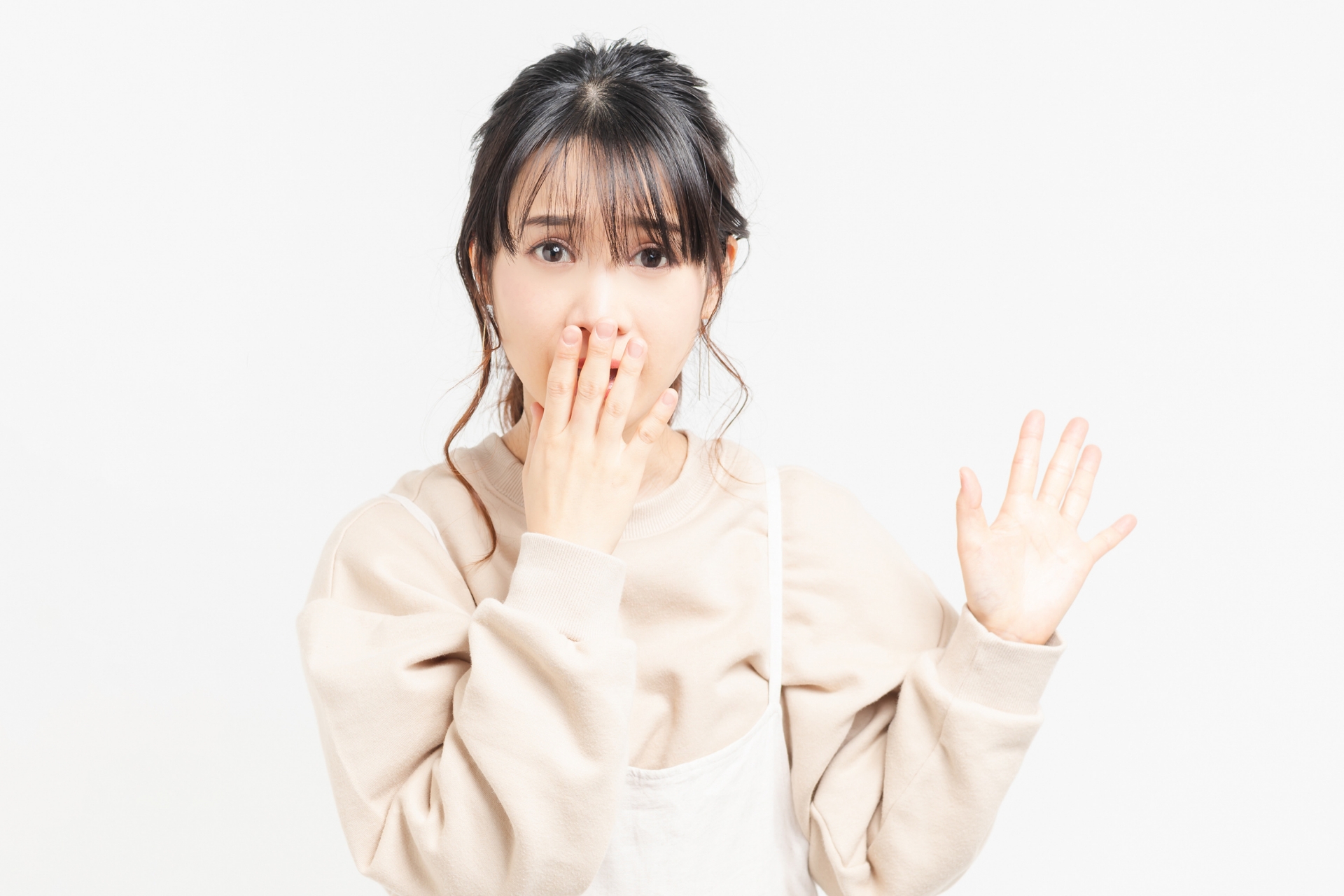 驚いて口を隠す女性