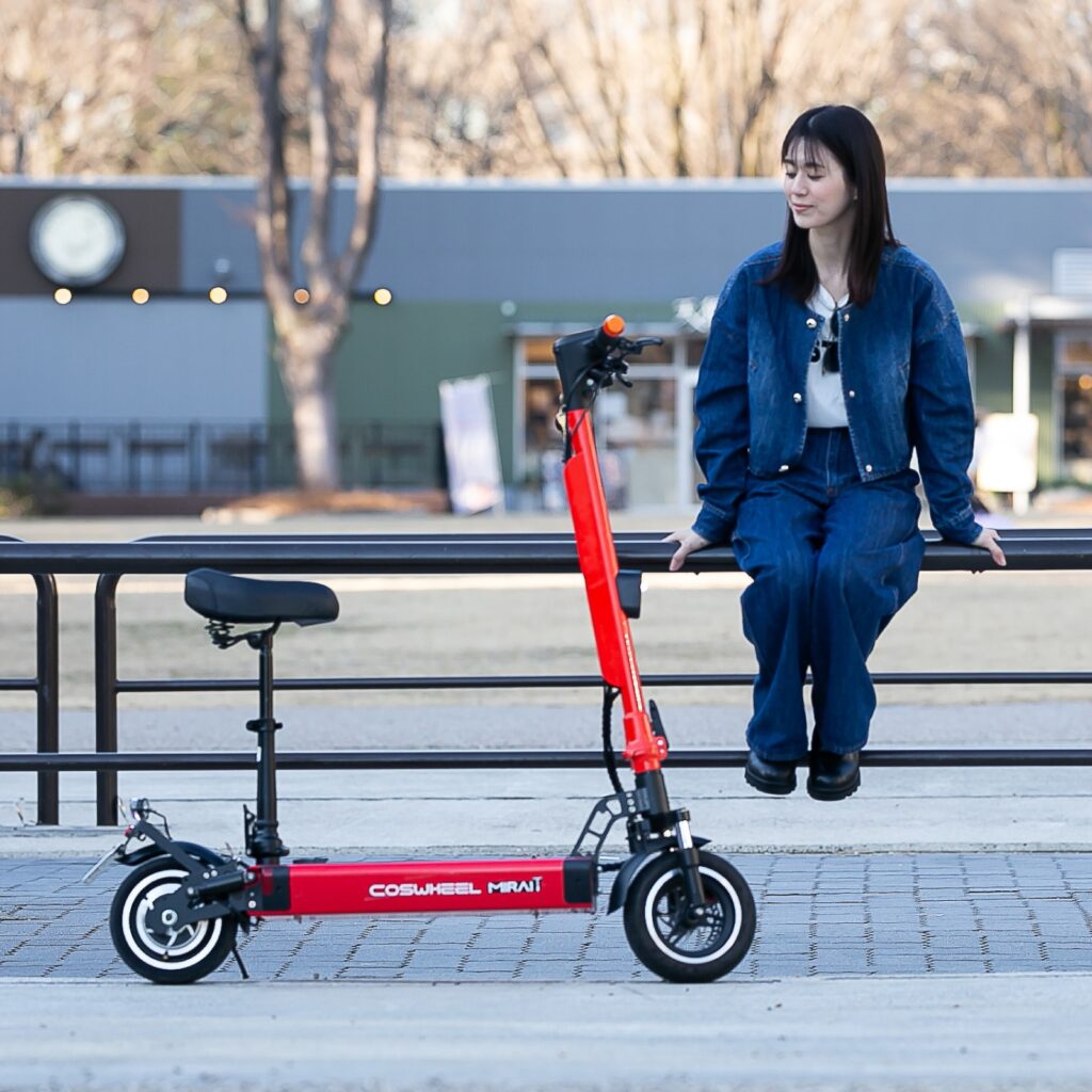 赤い電動キックボードとデニムの女性