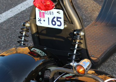ナンバープレート付き黒い電動バイクの後ろ